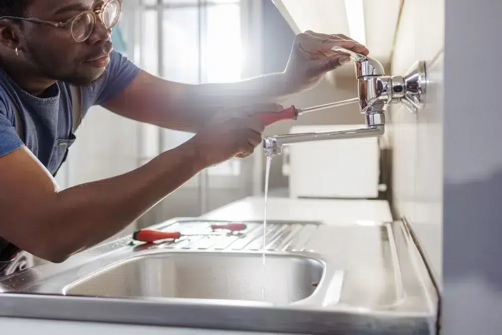 Plumber working on kitchen sink in Franklin, MA.