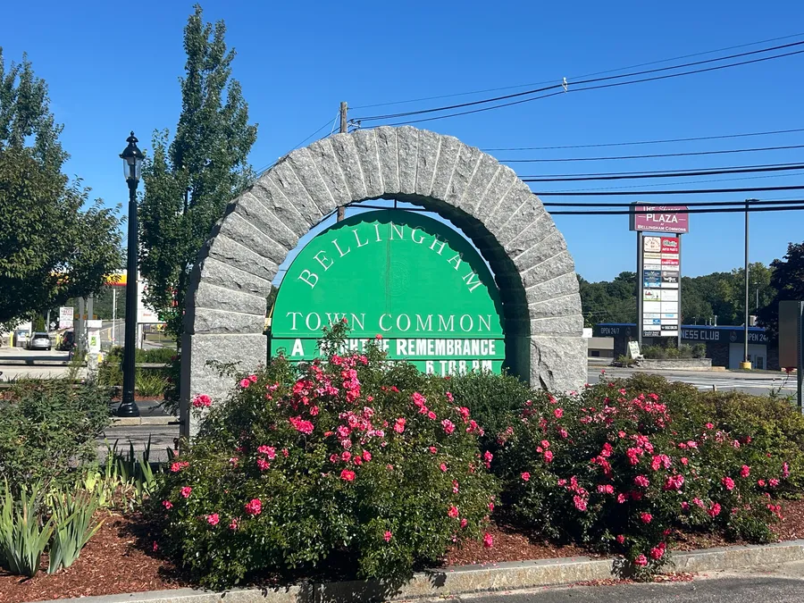 Bellingham Town Common sign surrounded by flowers in Bellingham, MA.