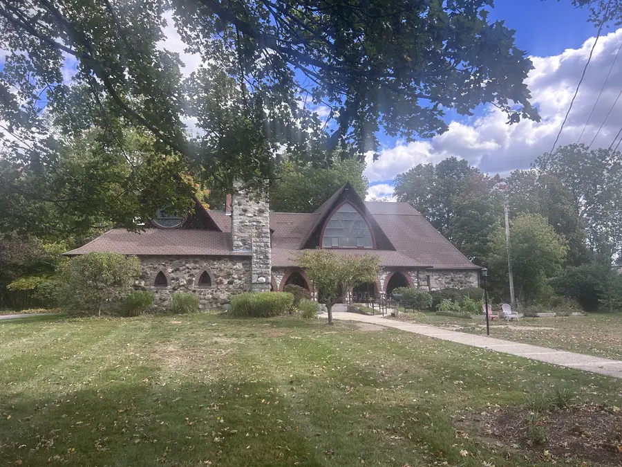Historic stone building with a round gable window in Medway, MA.