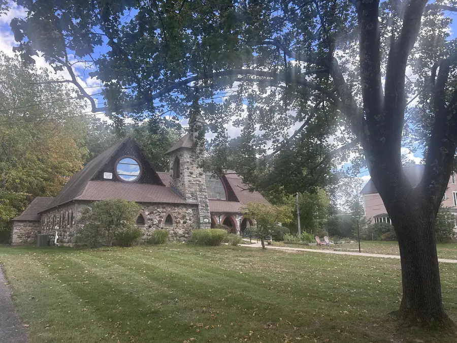 Historic stone building with a round gable window in Medway, MA.