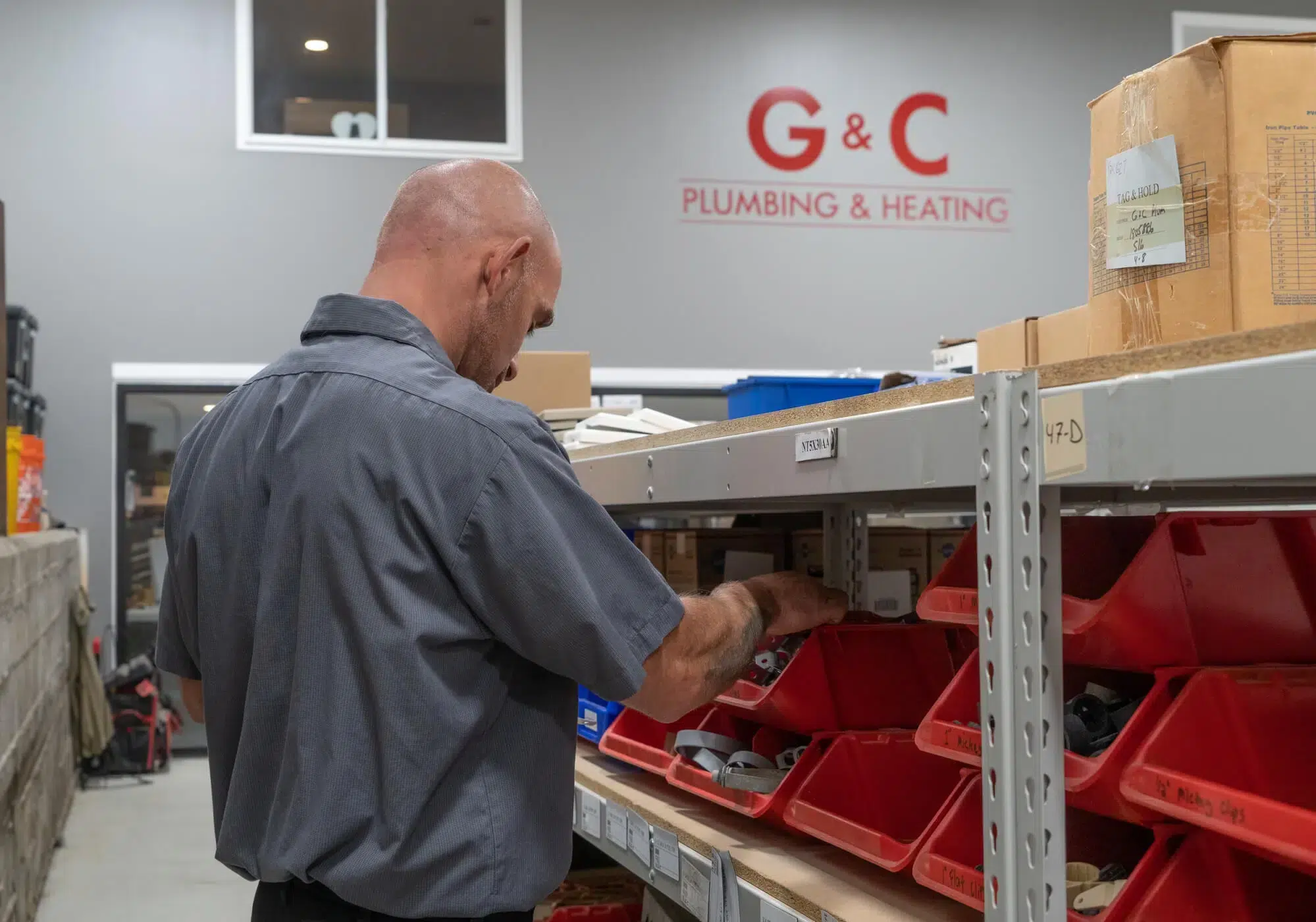 Technician picking out plumbing fixture in G&C Plumbing & Heating warehouse in Franklin, MA.