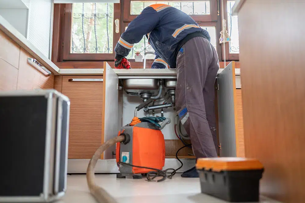 Technician fixing garbage disposal in Franklin, MA.